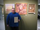 Alexey Akindinov with a certificate of honor in front of his paintings. Opening of the exhibition \"Inspiration by Ornament-2024\". Lyubertsy Art Gallery, 02/03/2024.