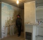 Alexey Akindinov against the wall painting \" Elven city.\" Wall number 2 . 