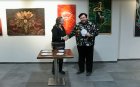 Ceremonial awarding of Alexei Akindinov. A member of the jury of the Eurasian Art Union presents Alexei with a diploma of the II degree. International exhibition-competition \"World of Esotericism\", gallery \"Art-Commune\", Moscow, st. Kyiv, 2. April 22