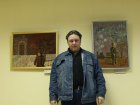 Alexey with his pictures at the exhibition.