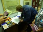 Alexey Akindinov signs the catalogs presented to the audience. Zakharovsky museum of local lore, opening of a personal exhibition of Alexey Akindinov \"My small Homeland\", on June 2, 2016, Ryazan region, Russia.