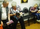 The audience considers catalogs with Alexey Akindinov\'s creativity. Zakharovsky museum of local lore, opening of a personal exhibition of Alexey Akindinov \"My small Homeland\", on June 2, 2016, Ryazan region, Russia.