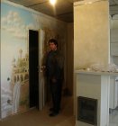 Алексей Акиндинов открывает скрытую дверь, на фоне настенной росписи \"Эльфийский город\". Стена №2.