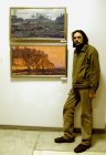 Artist Maksimiljan Presnyakov near his pictures.