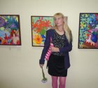 Художница - Елена Гонтаренко на фоне своих картин. 